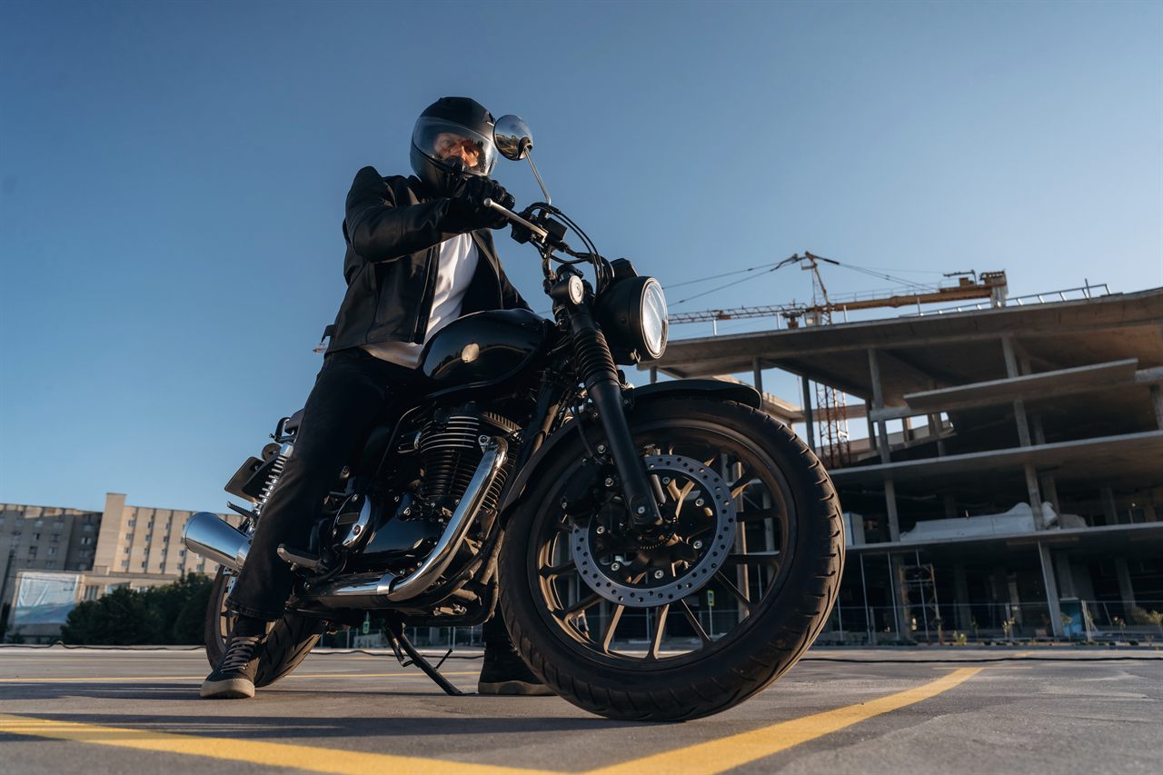 Motard en ville au guidon de sa moto, assuré en responsabilité civile