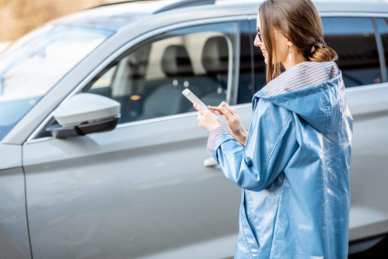 Automobiliste vérifiant sur son smartphone si son véhicule est assuré au FVA