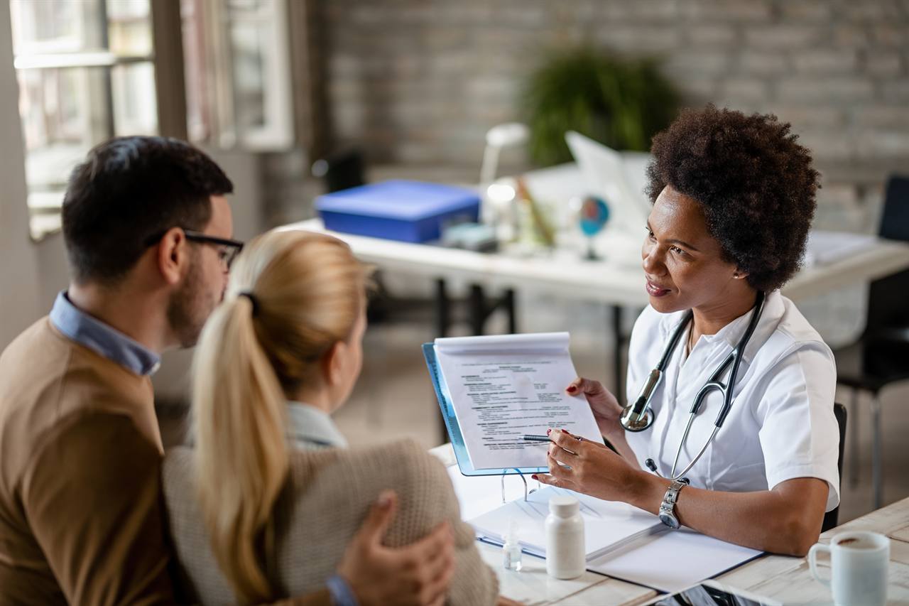 Un couple en consultation avec un médecin, illustrant le remboursement des soins par la mutuelle santé